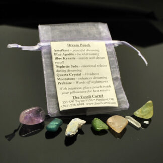 A healing stone pouch set featuring tumbled amethyst, blue apatite, kyanite, nephrite jade, moonstone, quartz crystal, and prehnite against a black background