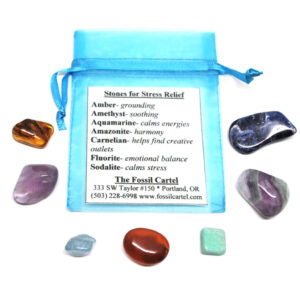 A stress relief healing pouch featuring amber, amethyst, aquamarine, amazonite, fluorite, and sodalite tumbled stones along with a blue organza pouch against a white background