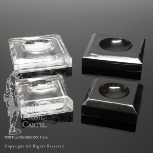 Clear and black square dimple block acrylic stands against a black background