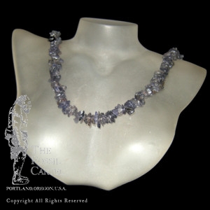 A tumbled iolite chip necklace against a black background