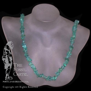 A tumbled blue apatite chip necklace against a black background