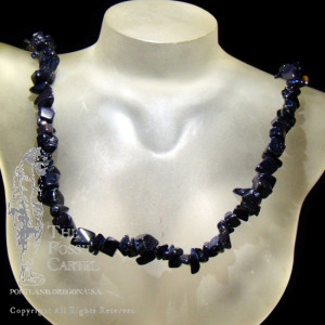 A tumbled blue goldstone chip necklace against a black background
