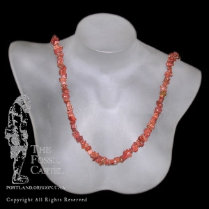 A tumbled goldstone chip necklace against a black background