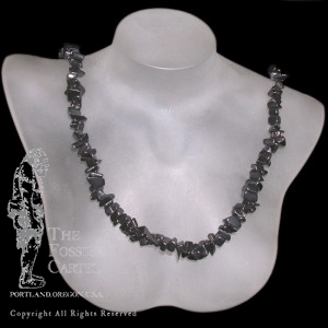 A tumbled hematite chip necklace against a black background