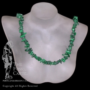 A tumbled malachite chip necklace against a black background