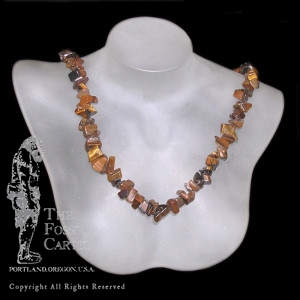 A tumbled tiger's eye chip necklace against a black background