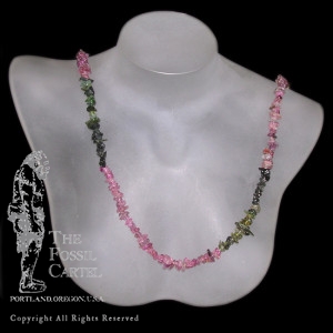 A pink and green tourmaline chip necklace against a black background