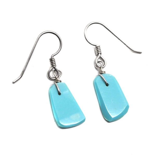 A pair of kingman turquoise sterling silver earrings against a white background
