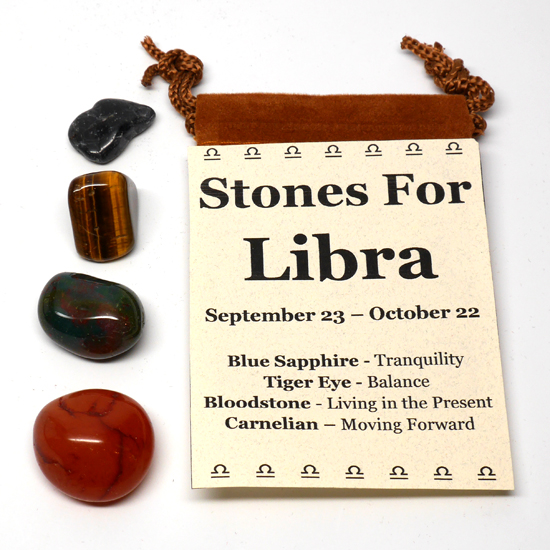 An astrological healing stone pouch for libra featuring blue sapphire, tiger's eye, bloodstone, and carnelian tumbled stones with a felt pouch against a white background