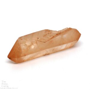 A clear quartz crystal with a rust-like coating due to iron and a notch in its side where another crystal once grew.