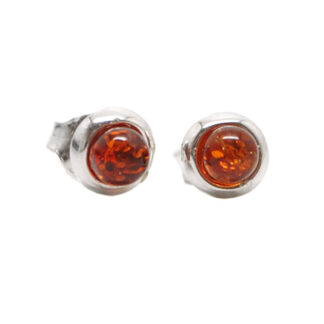 A pair of sterling silver stud earrings set with round amber cabochons against a white background