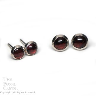 2 pairs of round garnet sterling silver stud earrings against a white background