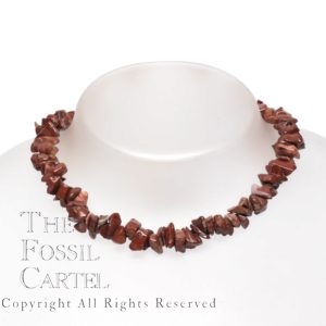 A necklace made of red tumbled brecciated jasper chips against a grey background