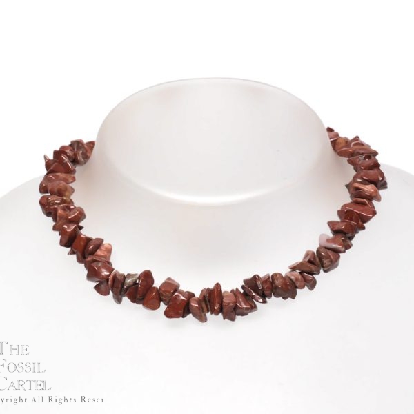 A necklace made of red tumbled brecciated jasper chips against a grey background