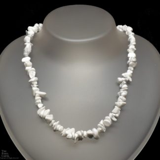 A necklace made of howlite chips against a black background