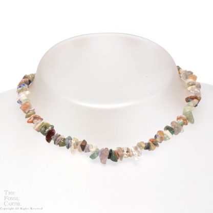 A necklace made of mixed stone chips against a grey background
