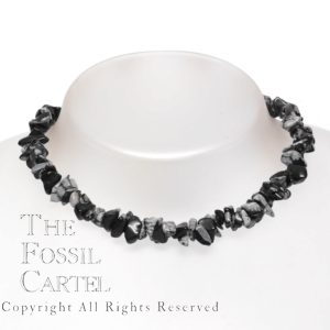 A stone chip necklace made of snowflake obsidian against a grey background