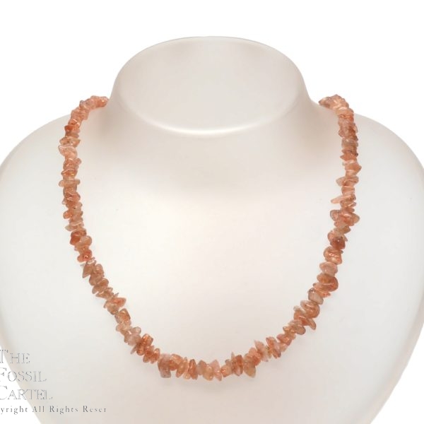 A necklace made of indian sunstone chips against a white background