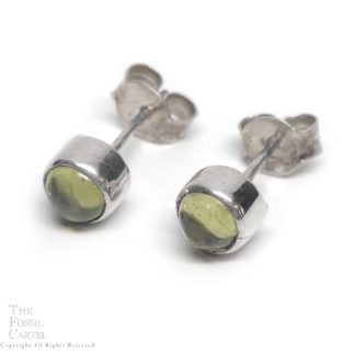 A pair of round sterling silver stud earrings with peridot cabochons against a white background
