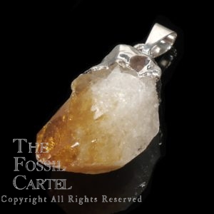 A treated citrine crystal point pendant capped in base metal against a black background