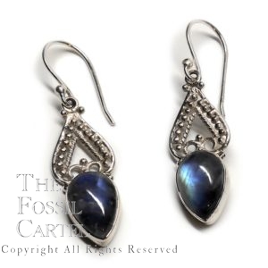 A pair of ornate sterling silver earrings featuring teardrop rainbow moonstone cabochons against a white background