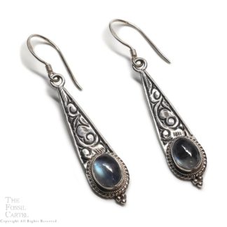 A pair of ornate sterling silver earrings featuring round rainbow moonstone cabochons against a white background