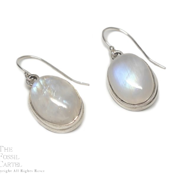 A pair of simple sterling silver earrings with oval rainbow moonstone cabochons against a white background