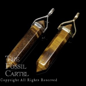 Two simple crystal shaped tiger's eye pendants set in sterling silver and gold plated against a black background
