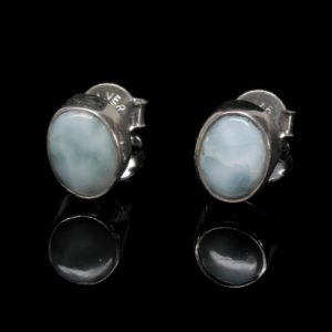 A pair of round sterling silver larimar stud earrings against a black background