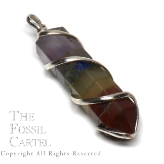 A simple spiral wire wrapped crystal-shaped chakra pendant with 7 different stones against a white background