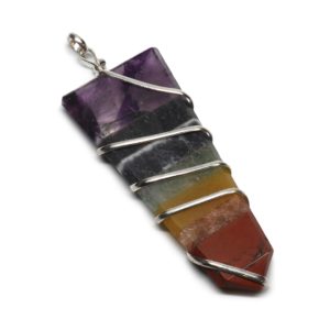 A simple spiral wire wrapped crystal-shaped chakra pendant with seven different stones against a white background