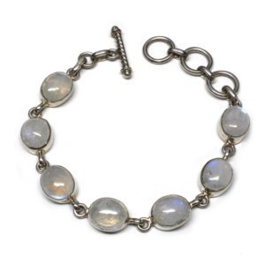 A sterling silver bracelet set with oval rainbow moonstone cabochons against a white background