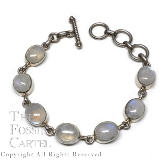A sterling silver bracelet set with oval rainbow moonstone cabochons against a white background