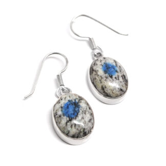 A pair of daingly sterling silver earrings set with oval K2 granite cabochons against a white background