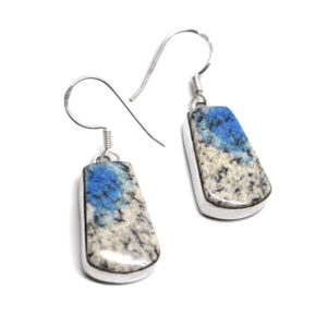 A pair of daingly sterling silver earrings set with rectangular K2 granite cabochons against a white background