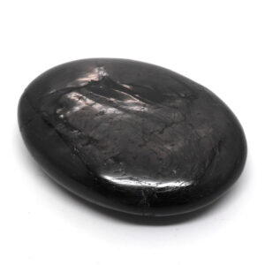 A polished hypersthene palm stone against a white background