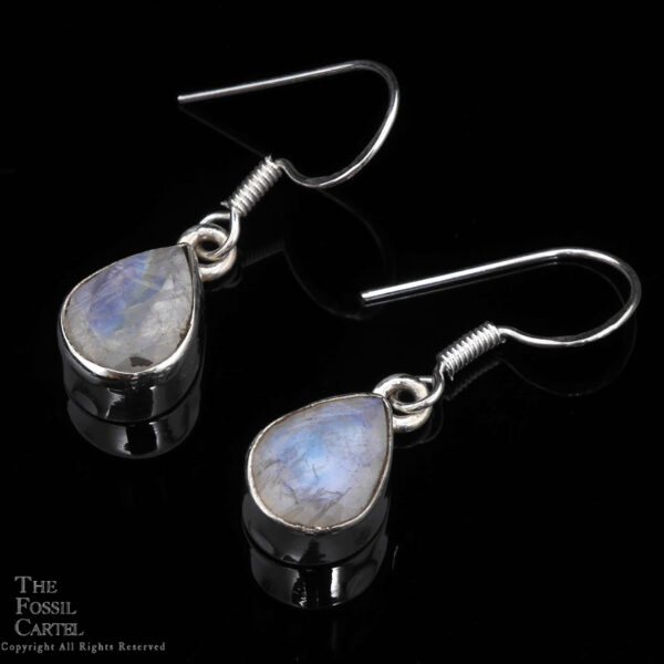 A pair of sterling silver rainbow moonstone teardrop dangle earrings against a black background