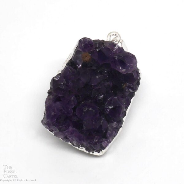 A small cluster of dark purple amethyst crystals with silver-colored electroplating affixed to a bail which it hangs from to be worn as a pendant