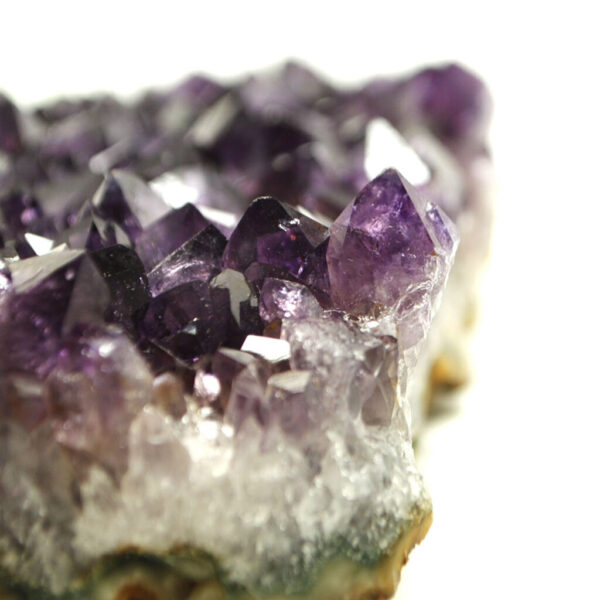 A purple amethyst crystal cluster against a white background