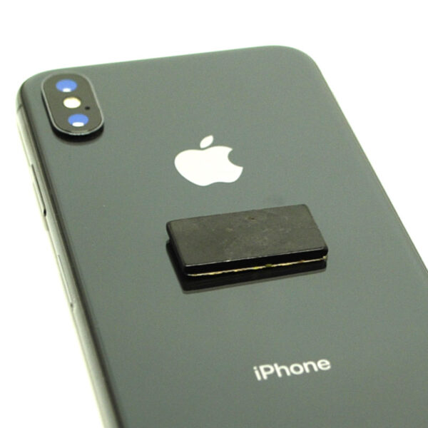 A rectangular shungite phone tile on a grey smart phonesticker against a white background