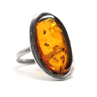 A sterling silver ring with a thin band featuring an oval baltic amber cabochon against a white background