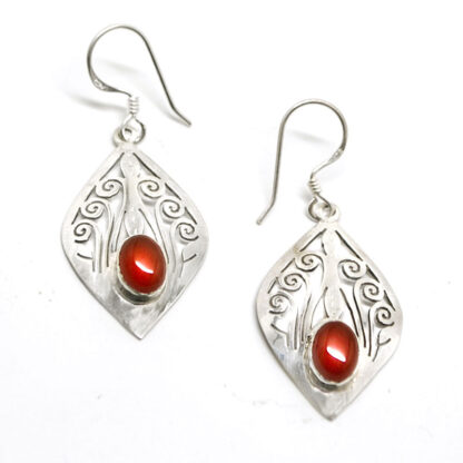 A pair of decorative sterling silver earrings set with deep orange carnelian agate cabochons against a white background