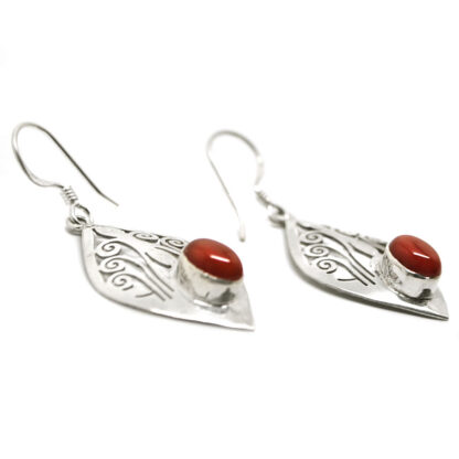 A pair of decorative sterling silver earrings set with deep orange carnelian agate cabochons against a white background