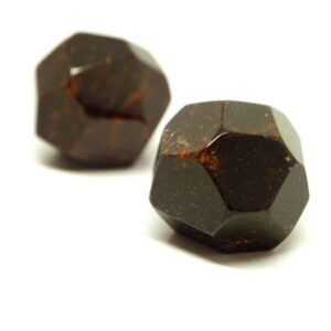 A pair of almandine naturally formed polished garnet crystals against a white background