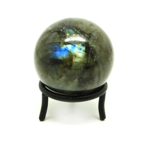 A colorful polished labradorite sphere in a circular iron stand against a white background