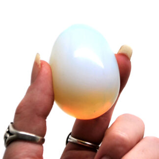 A polished opalite egg against a white background