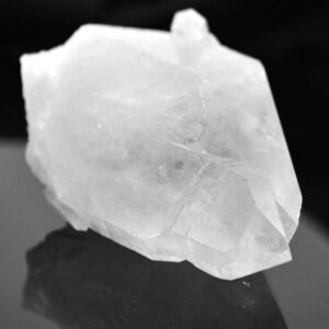 A clear quartz crystal against a black background