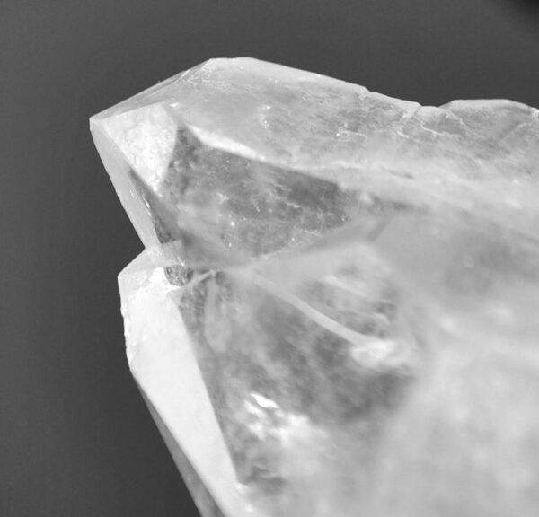 A clear quartz crystal against a black background