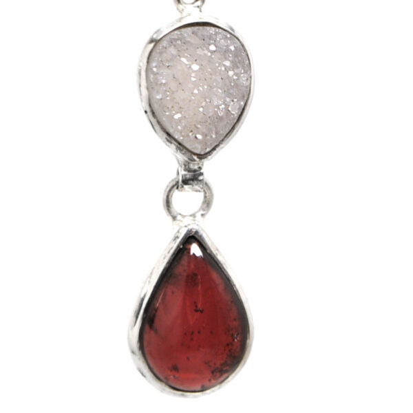 A pair of sterling silver dangle earrings featuring druzy quartz and red garnet gemstones against a white background
