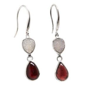 A pair of sterling silver dangle earrings featuring druzy quartz and red garnet gemstones against a white background